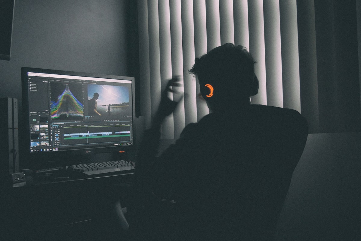 shallow focus photography of man listing to music in front of the computer
