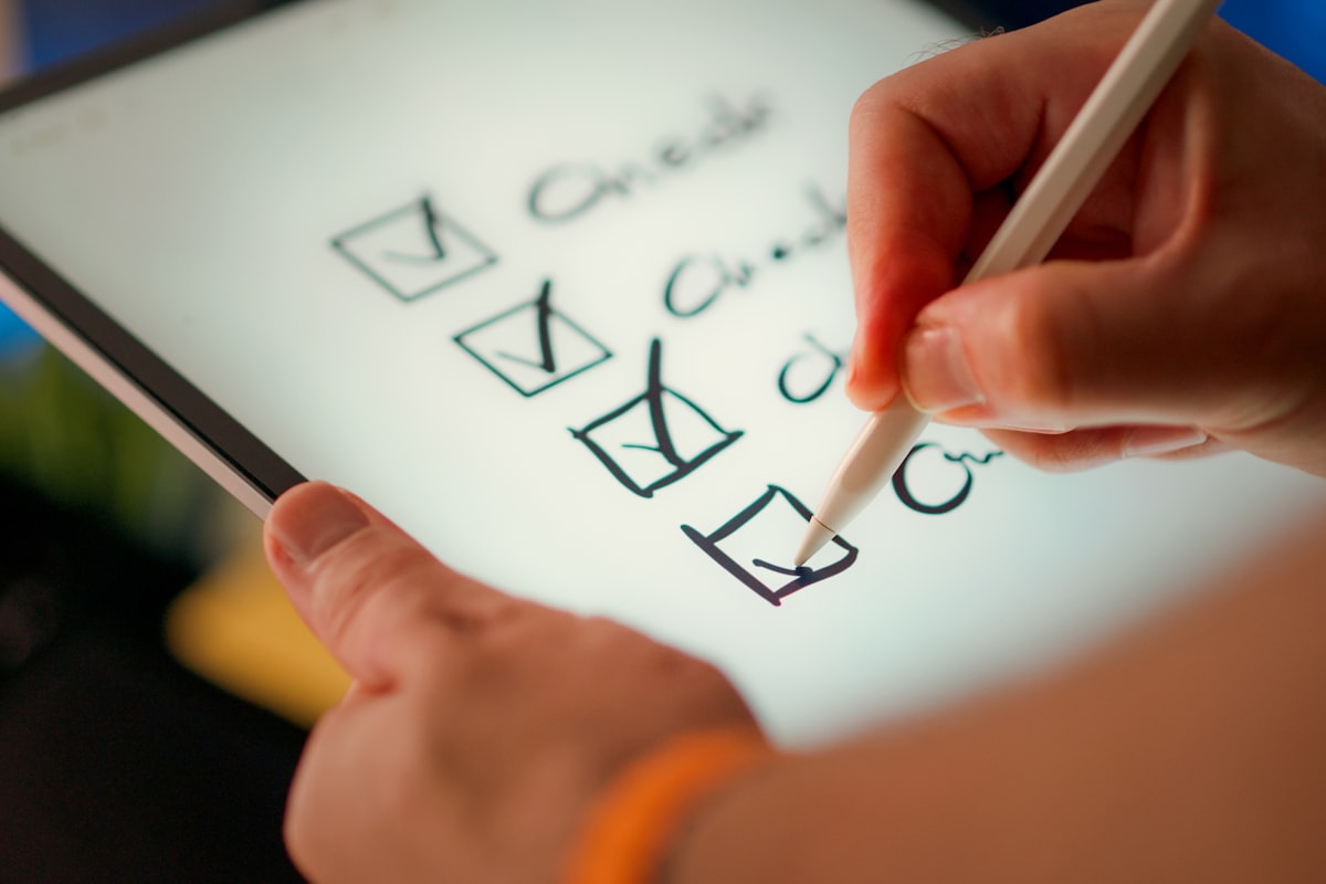 A hand marks off items on a checklist.