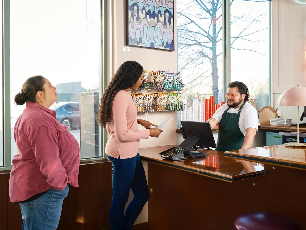 Customers interact with a cashier at a counter.