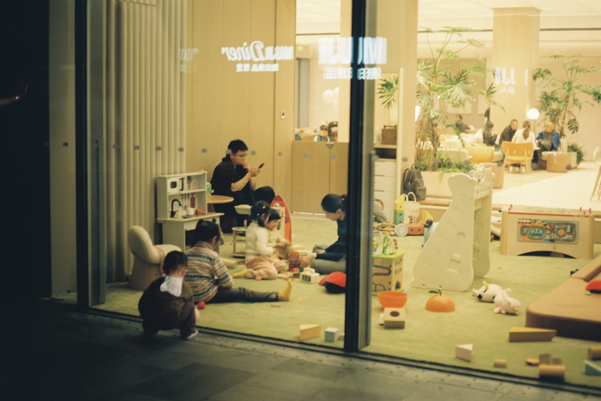 Adults and children playing with toys through a window
